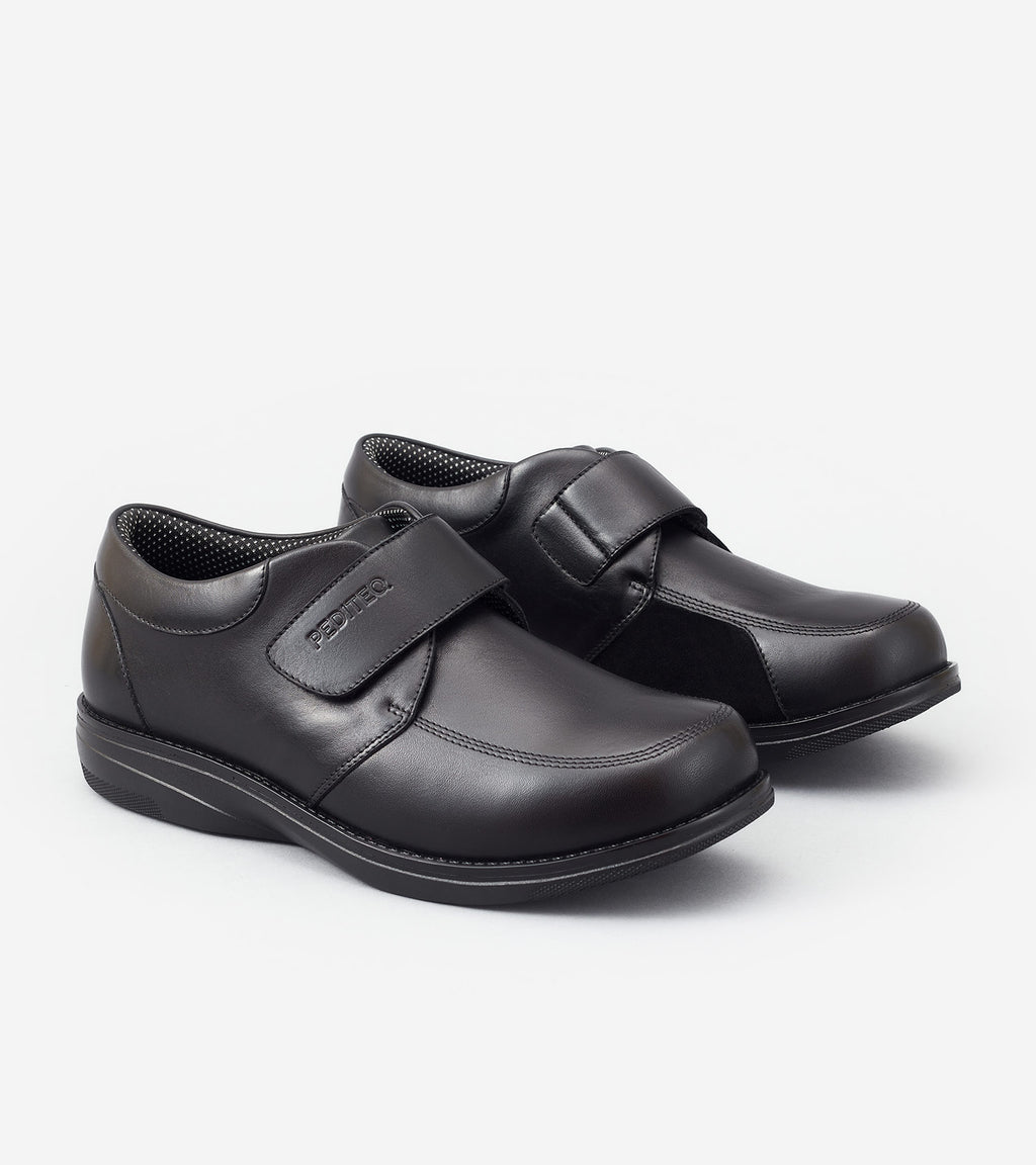 Pair of black shoes with velcro straps on a white background