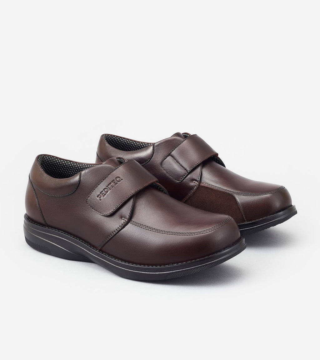 Pair of brown shoes with velcro straps on a white background