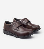 Pair of brown shoes with velcro straps on a white background