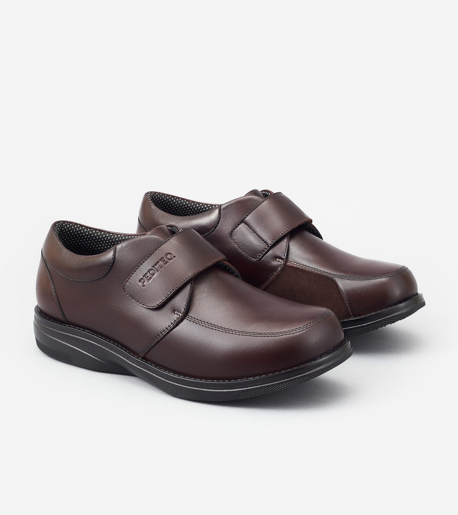 Pair of brown shoes with velcro straps on a white background