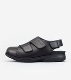 Black shoe with velcro straps on a white background