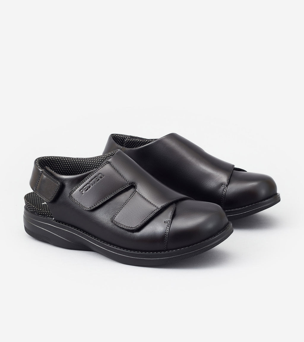 Pair of black shoes with velcro straps on a white background