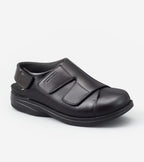 Black shoe with velcro straps on a white background